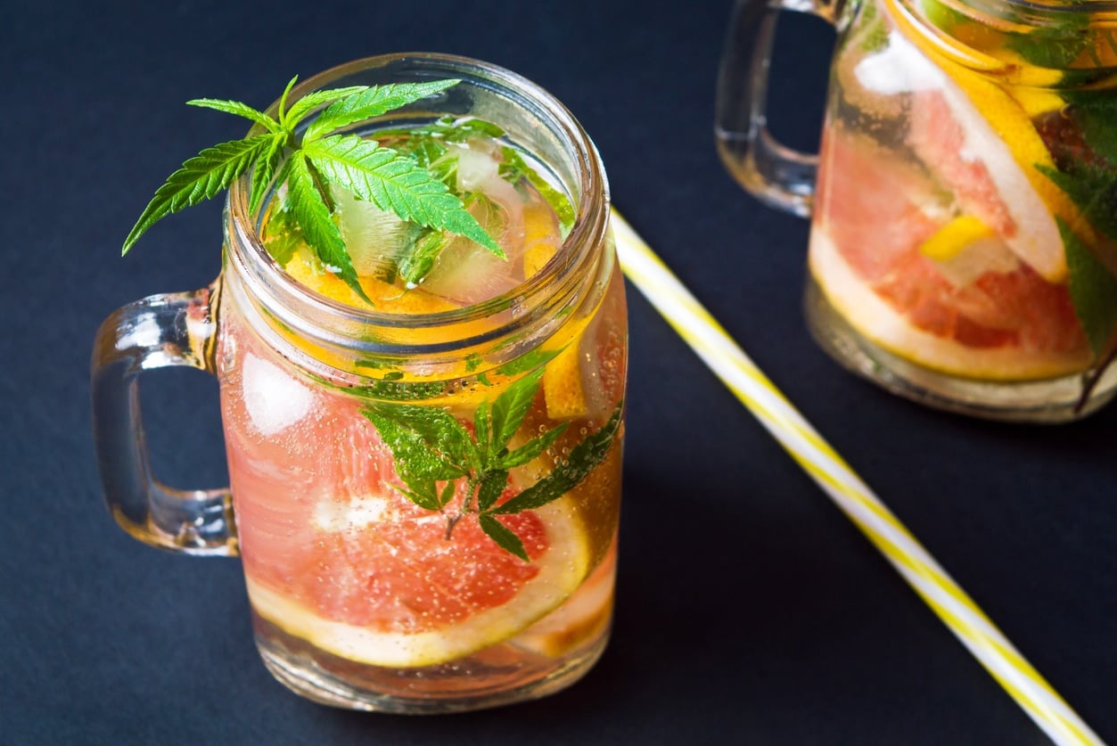 Grapefruit smoothie with marijuana leaves in jars